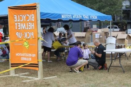 people outside under a tent at a bicycle helmet pick-up